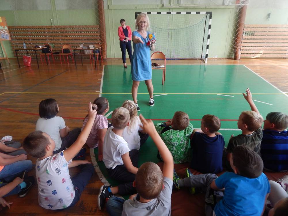 Sala gimnastyczna. Beata Ostrowicka rozmawia z dziećmi.