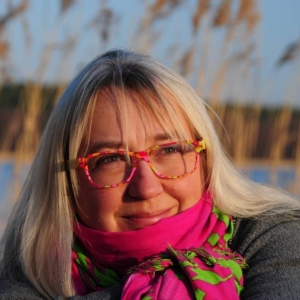 Autorka, Agnieszka Frączek na tle jeziora lub stawu, w okularach i różowym szaliku