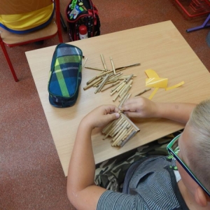 Dzieci wykonują domek z trzciny.