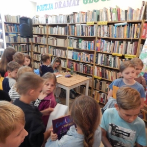 Biblioteka, dzieci stoją w kolejce po zakup książki oraz autograf
