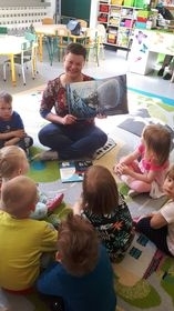 Przedszkole w Ślesinie, dzieci siedzą na dywanie, słuchają czytanego opowiadania.