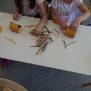 Dzieci wykonują chatkę z trzciny.